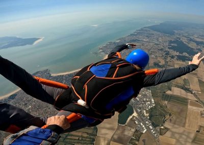 Encadré par un moniteur, un élève en parachute