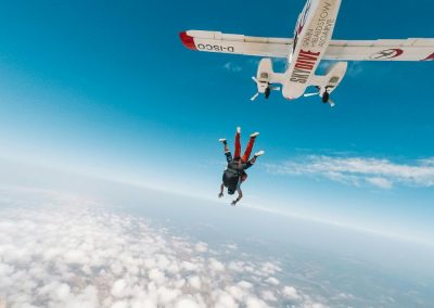 Sortie de l'avion lors d'un tandem de parachute au dessus des nuages